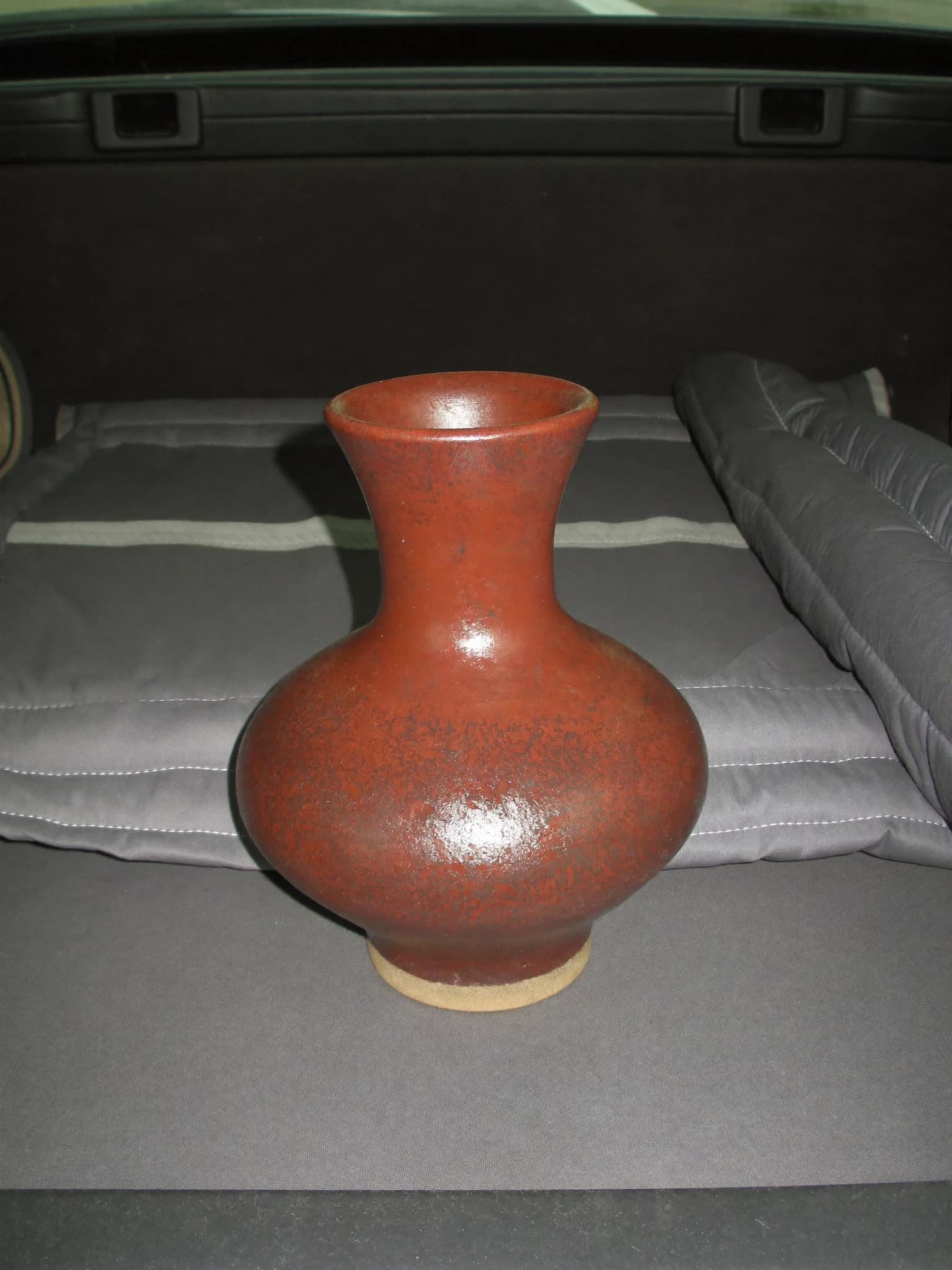 A round-bellied clay-red stoneware bottle vase with a long neck
